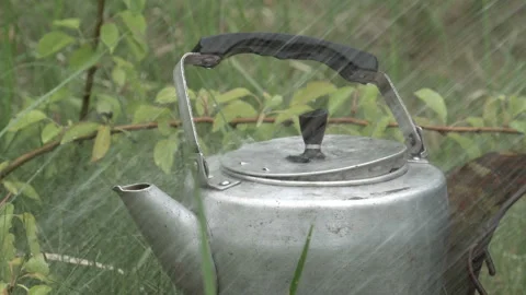 Water poured kettle on a background of grass 4K Video stock 90682756