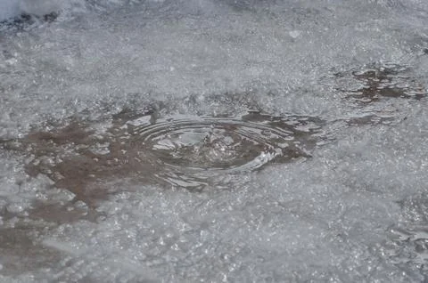 Water poured into a puddle on the ice to thaw Stock Photos