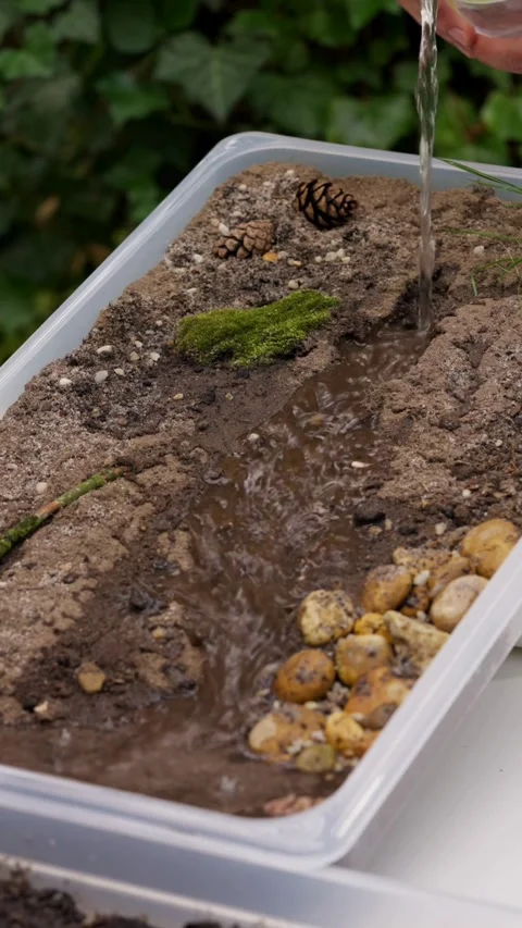 Water poured into soil model creating stream and erosion 스톡 동영상 331770110
