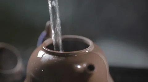 Water pouring into earthenware teapot Stock Footage 56353724