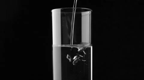 Water pouring into the glass on black Stock Footage