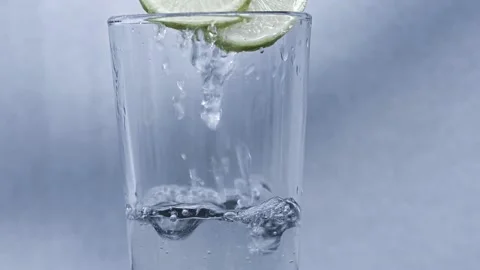 Water is Pouring Into a Glass with lemon Stock Footage 218344797