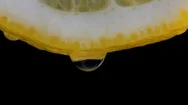 Water Pouring On Half Slice Cut Of Fresh Lemon Againts Black Background Stock Footage