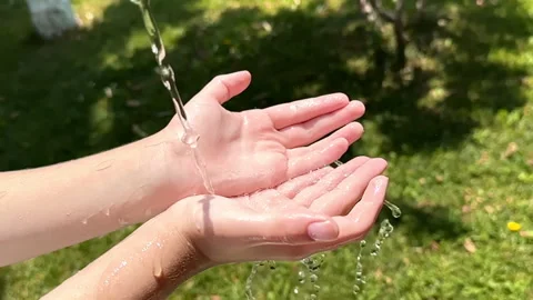 Water pouring to a hand Stock Footage 245348248