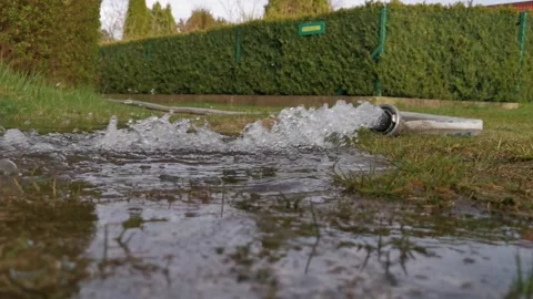 Water pouring from a hose, pulling water out of a flooded house Stock Footage 306723403