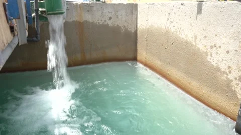 Water Pouring from Large Green Pipe into Concrete Basin of Turquoise Water Vídeos de archivo 334623359