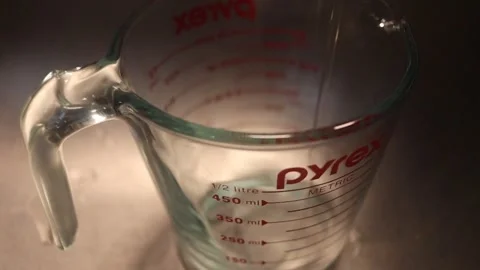 Water pouring into measuring cup Stock Footage 169786525