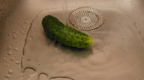 Water pouring over a cucumber in a sink 库存影片 11908649