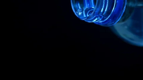 Water is pouring from a plastic bottle on a black background Stock Footage 121521853