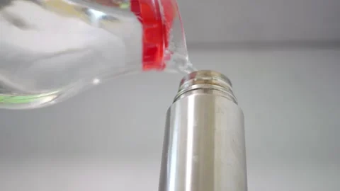 Water pouring thin stream transparent glass carafe stainless steel thermos clear Video stock 320897794