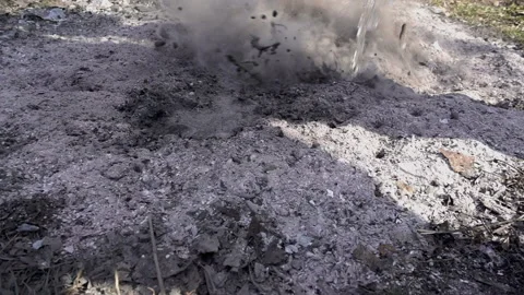 Water pours into an extinct fire in slow motion Stock Footage 152095630