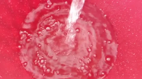 Water pours into a red bucket Stock Footage 330215652