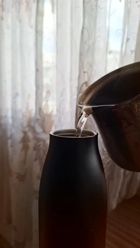 Water pours from a rustic metal pitcher Stock Footage 332469710