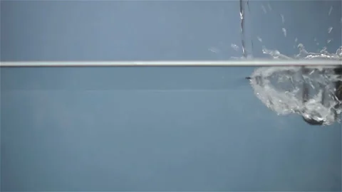 Water pours in slow motion onto the surface of the water. Stock Footage 137200917