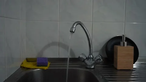 Water pours from the tap in the kitchen Stock-Footage 163120637