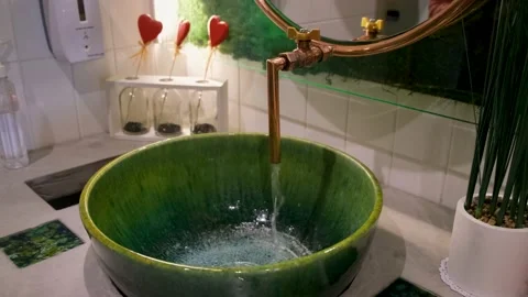 Water pours from the tap into the round stone sink Stock Footage 169965559