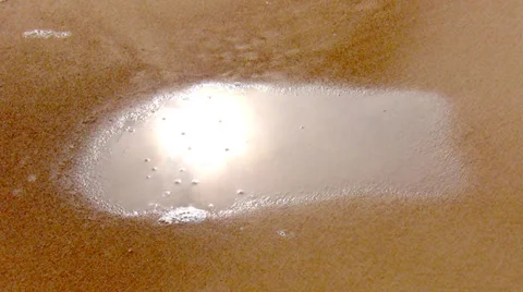 Water puddle absorbed by sand Stock Footage