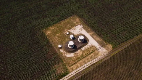 Water pump and storage system in rural area, surrounded by green fields, Stock Footage 312742271