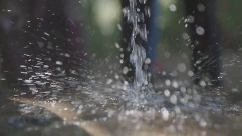 Water from a pump splashing on the ground Stock Footage 74390574