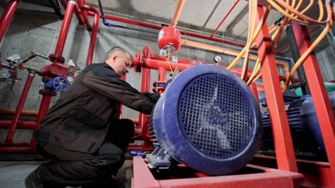 A water pumping station engineer repairs the water supply compressor engine. Vídeo Stock 158600564