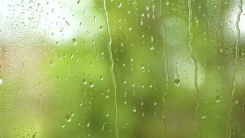 Water rainfall, vertical rain drops texture on window glass, blurred green trees Video stock 193915947