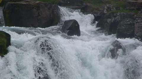 Water on rapids running over volcanic rock in the Icelandic fjords Stock Footage 37270627