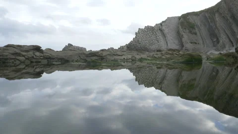 Water reflecions of ocean cliffs in Spain 4K Stock Footage 137710309