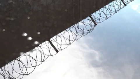 The water reflection of a concrete wall with barbed wire. Passing the guard Stock Footage 129792842
