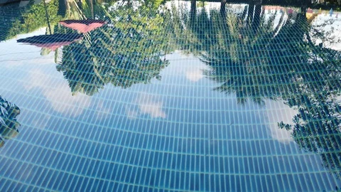 Water reflection of small hotel resort pool area with no people Video stock 107353224