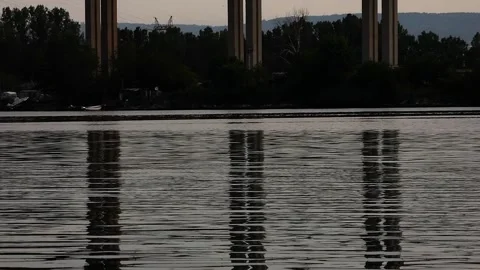 Water reflections on a high bridge and the traffic on it Stock Footage 308935791