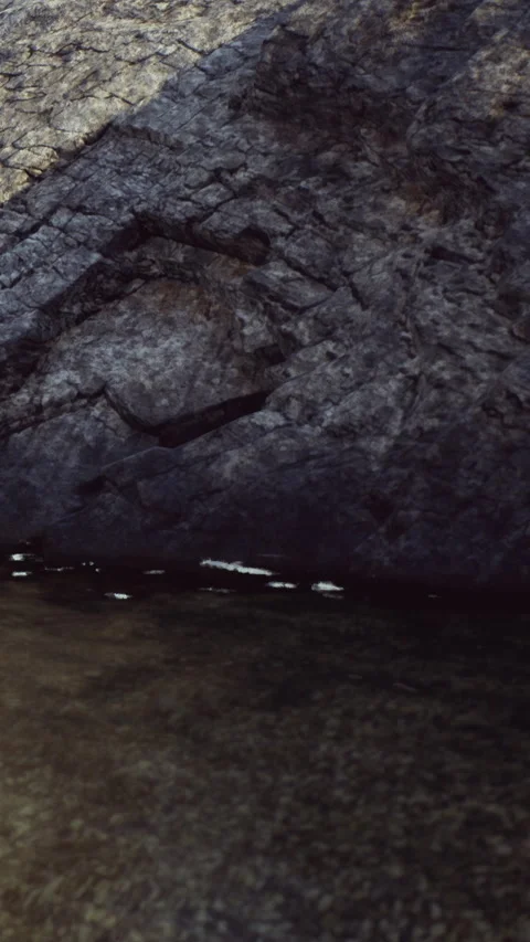 Water reflects light against the stone wall in a cave near the ocean Stock Footage 340646236