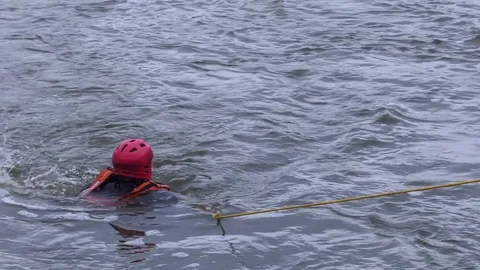 Water rescue man pulled in by rope during training 4k Stock Footage 78079616