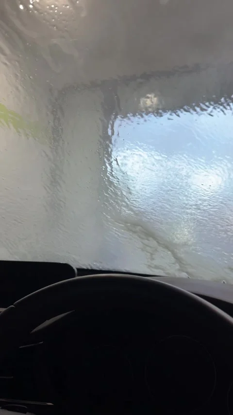 Water Rinsing Off Windshield Inside Automatic Car Wash from Driver's Perspe.. Stockbeeldmateriaal 340679658