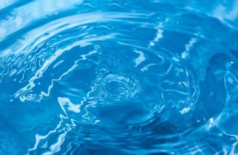 Water ripple background. Splashes from a drop of water. Raindrops on a blue b Photos
