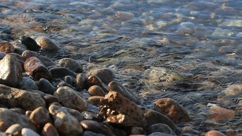 Water ripple on waves. Pebble stone on shore in sunny spring morning. Beautiful Stock Footage 144282301