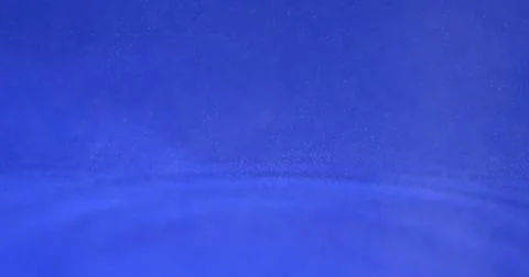 Water ripples create patterns in blue liquid during a clear day in a calm Stock Photos