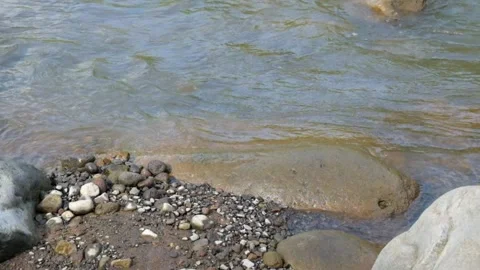 Water ripples on the edge of the river with sand and stones Stock Footage 297654088