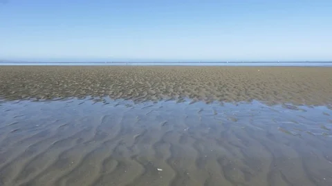 Water rising when tide changes from low to high on a beach, New Zealand Stock Footage 75860089