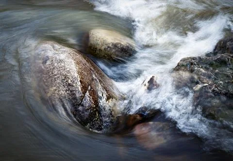 The water of the river flows around the stones Stock Photos
