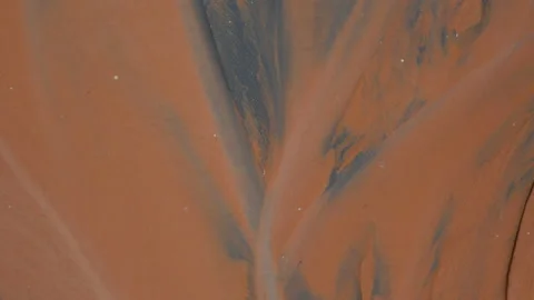 Water from a river flows over black and orange volcanic sand, in Vietnam Stock Footage 232387406