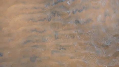Water from a river flows over sand, in Vietnam Stock Footage 232383589