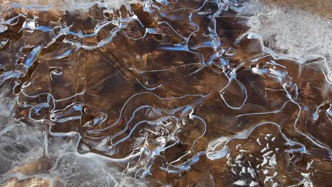 Water running below frozen river in the mountain Stock Footage