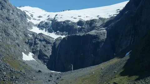 Water running down cliff with snow on top 스톡 동영상 260850489