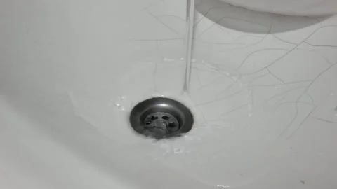 Water Running Down a Cracked Ceramic Sink Drain 動画素材 337625460