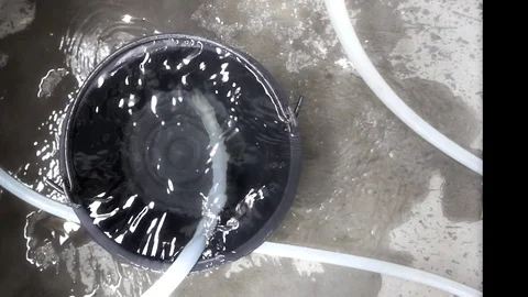 The water is running down the plastic bucket and overflowing. Video stock 75678903