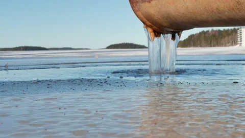 Water running out of drain pipe into frozen lake, Finland Stock-Footage 171664327