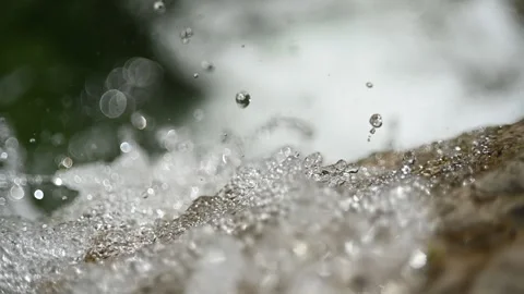 Water running over a rock into a pool from a mountain stream (slow motion) Video stock 219635865