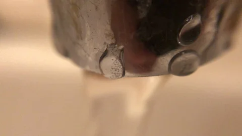 Water running from the rusty old tap into a sink. Stock Footage 129416910