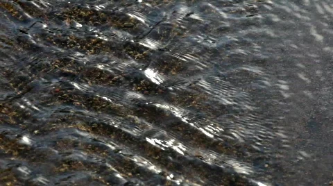 Water running in a small stream towards the sea.  Stock Footage