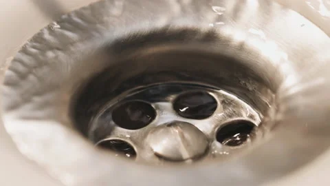 Water running through the drain of a sink. Slow-motion. Close-up. Stock Footage 183342569